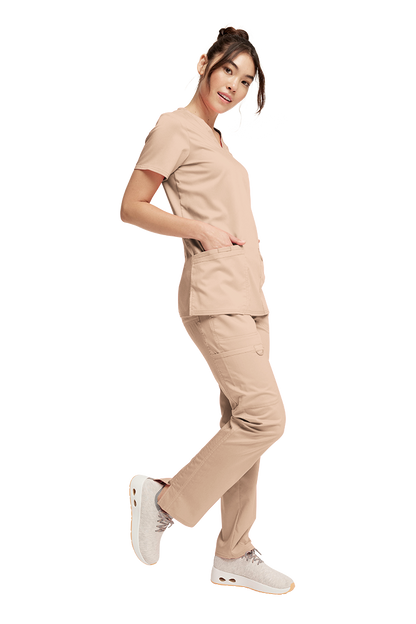 Woman wearing a beige Cherokee Revolution scrub se, WW620 Top and WW120 Pants 
