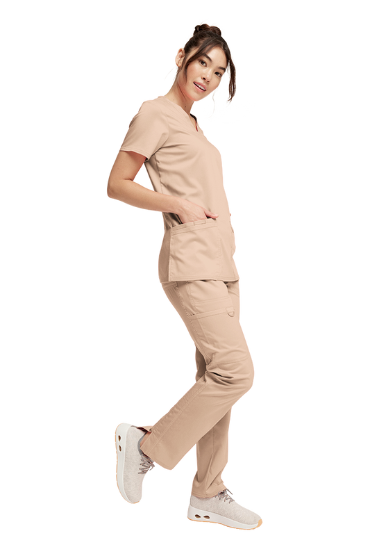 Woman wearing a beige Cherokee Revolution scrub se, WW620 Top and WW120 Pants 